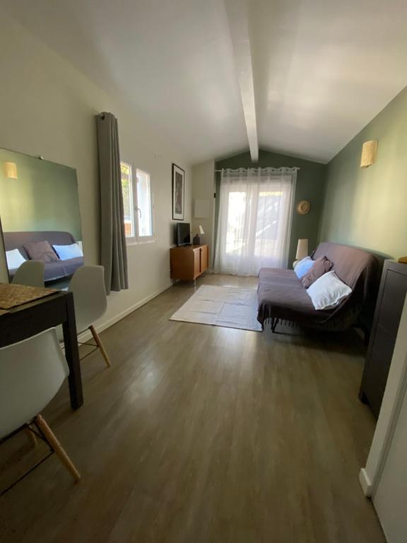 a living room with a bed and a couch at Studio indépendant avec terrasse dans propriété campagne Aixoise in Aix-en-Provence