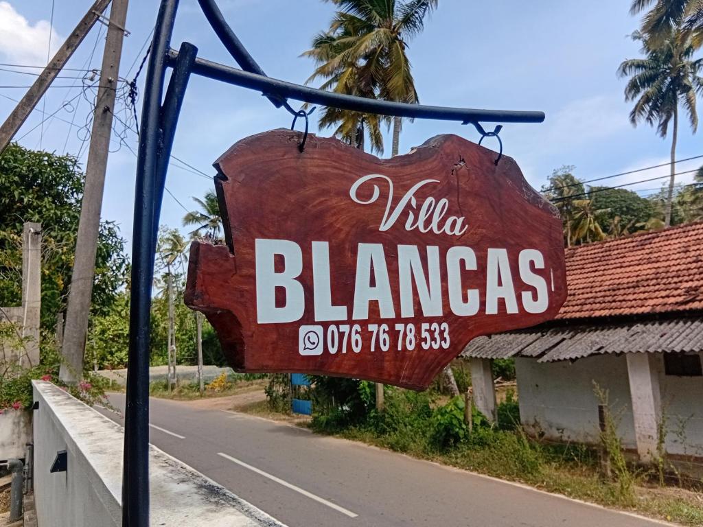 a sign for a pizza flamingos restaurant on the side of a road at Villa Blancas in Matara