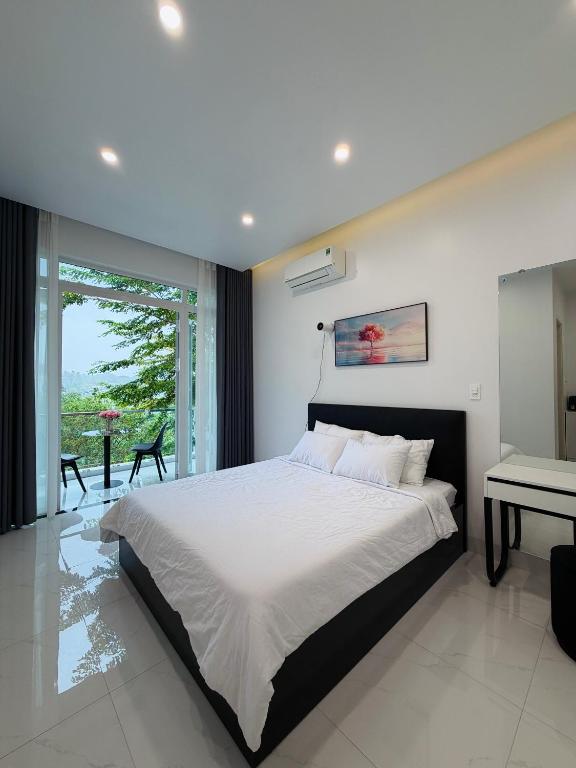 a bedroom with a large bed and a balcony at Niki Homestay in Thôn Dương Xuân Hạ