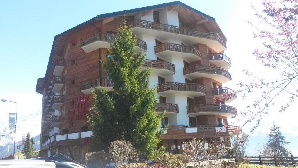 ein Gebäude mit Balkon auf der Seite in der Unterkunft Appartement - Bristol Hôtel in Villars-sur-Ollon