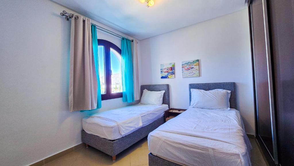 une petite chambre avec deux lits et une fenêtre dans l'établissement Séjour calme au Golf & Gardens, à Cabo Negro