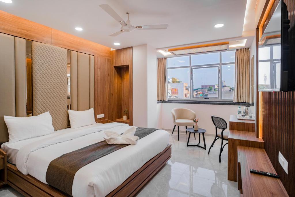 een slaapkamer met een bed, een bureau en een stoel bij Hotel SK Elite in Jodhpur