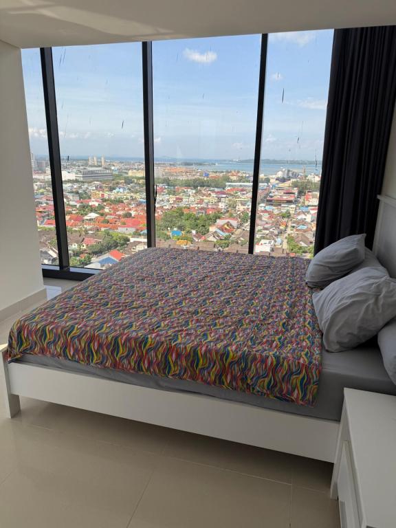 a bedroom with a bed in front of a large window at Luxury 2BR Sea View by Superstay in Batam Center