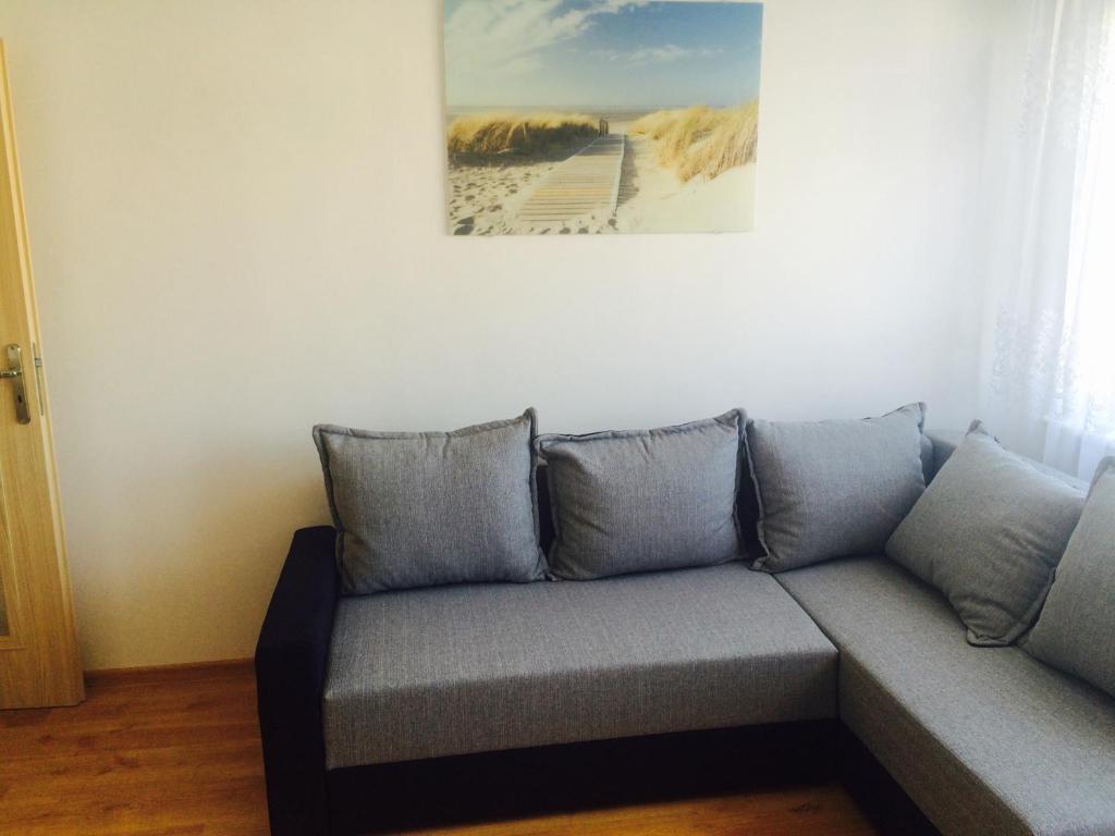 Śpiew Mew في أوستكا: أريكة في غرفة معيشة مع لوحة على الحائط