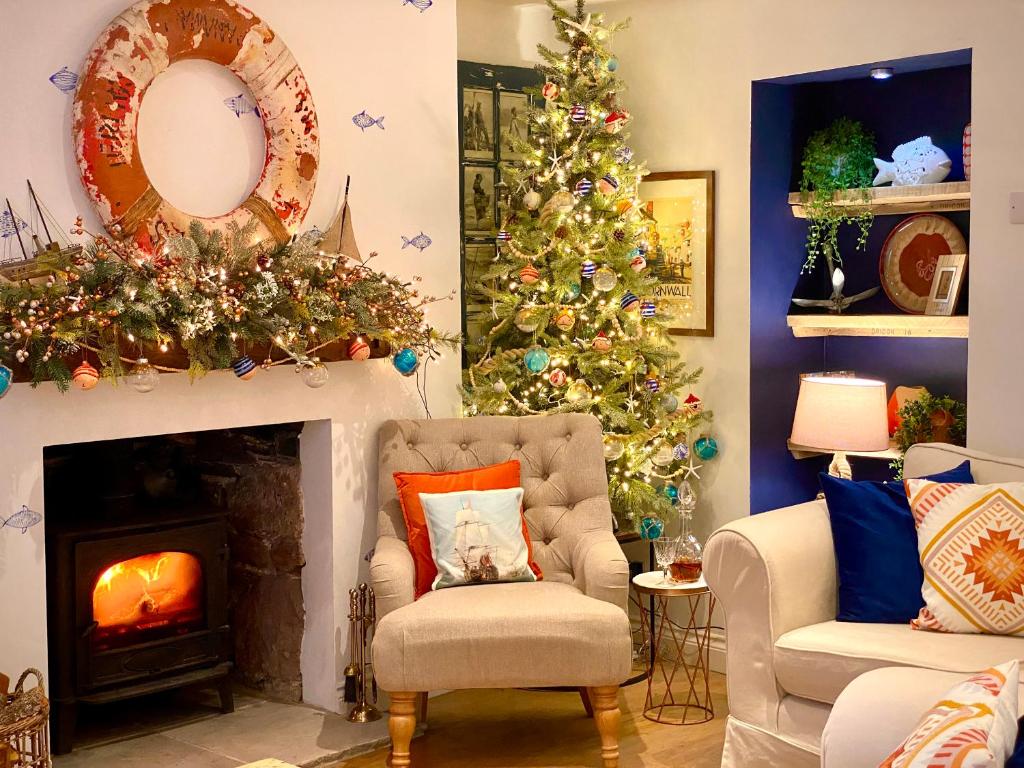 a living room with christmas trees and a fireplace at Pentreath in Torpoint