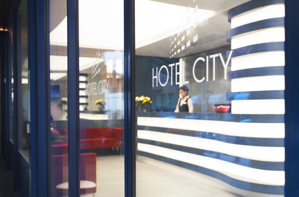 odbicie kobiety w oknie restauracji w obiekcie Hotel City Locarno w mieście Locarno
