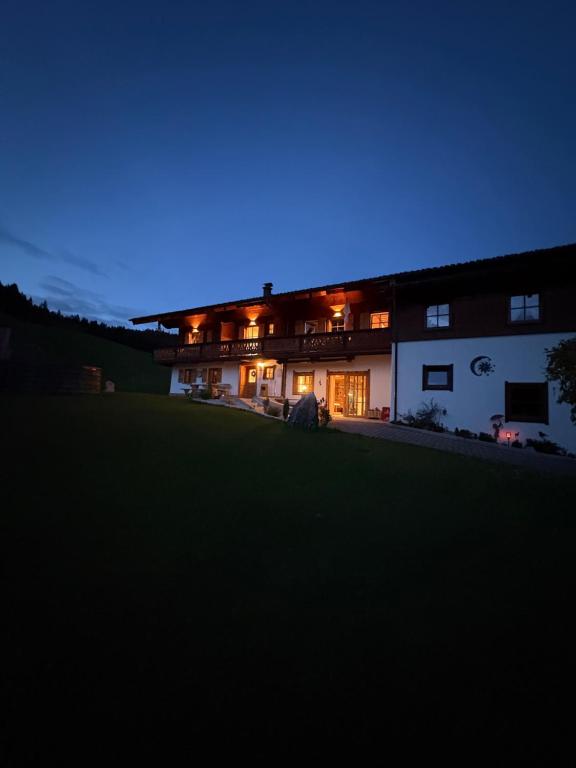 a house lit up at night with a blue sky at Ferienwohnung Datzmannlehen mit traumhaften Bergblick und Sauna in Ramsau