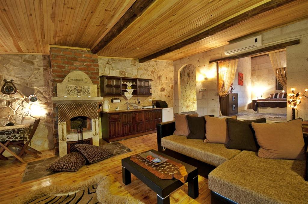 sala de estar con sofá y chimenea en Adanos Konuk Evi, en Avanos