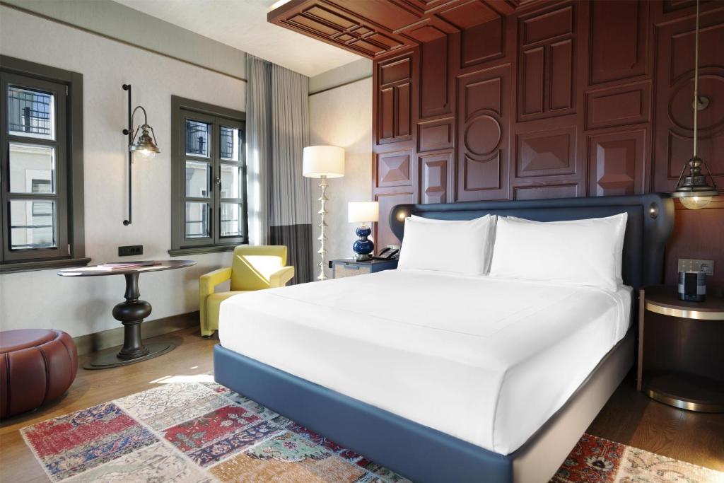 a bedroom with a large white bed and a desk at Canopy By Hilton Istanbul Taksim in Istanbul
