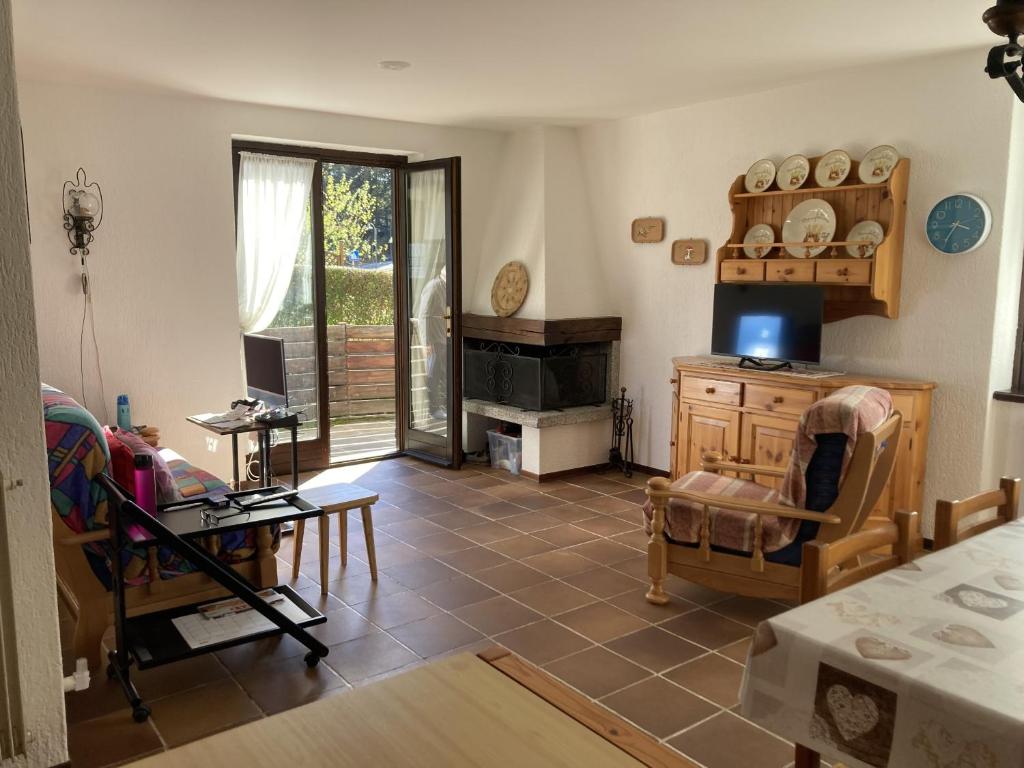 a living room with a fireplace and a table at 031 Trilocale piano terra, Giustino in Giustino