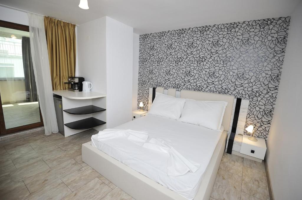 ヴァルナ・シティにあるPoshta 1 Apartment 2の白いベッドと壁が備わるベッドルーム1室が備わります。