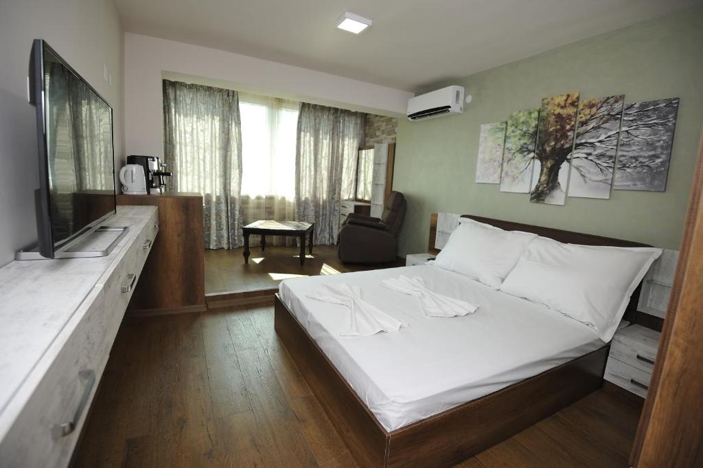 ヴァルナ・シティにあるPoshta 1 Apartment 3のベッドルーム(白いベッド1台付)、リビングルームが備わります。