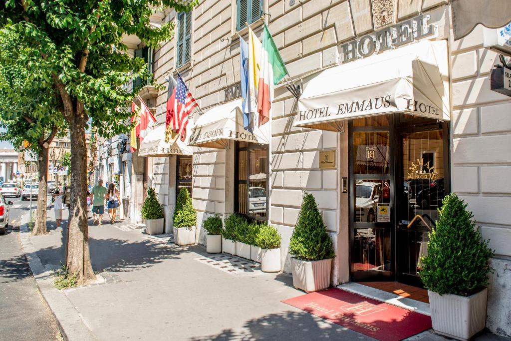 a street in front of a store with potted trees at Hotel Emmaus in Rome