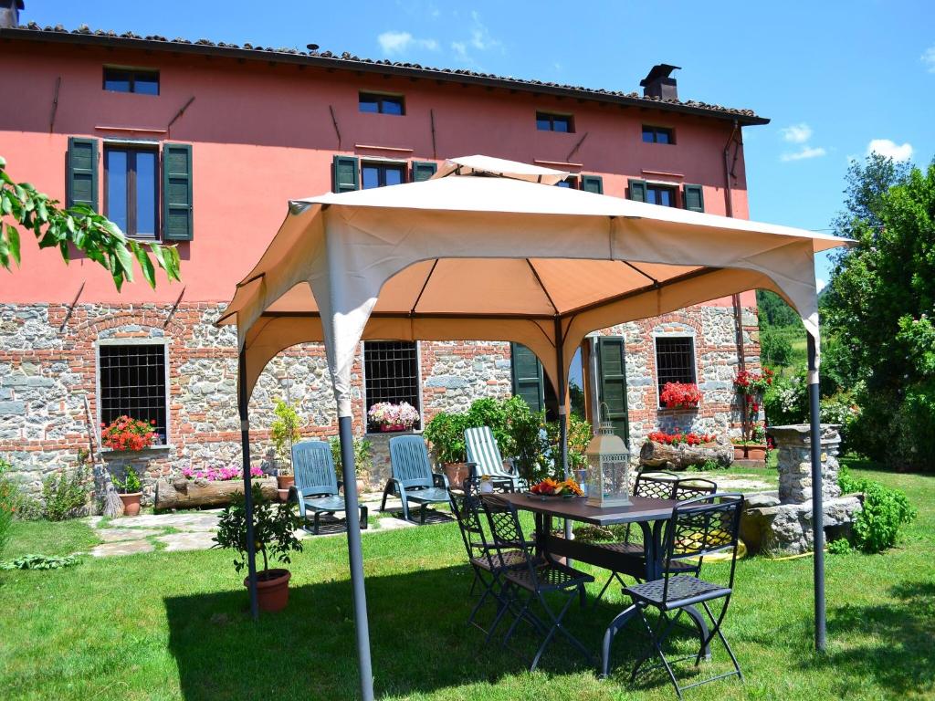 una mesa con sombrilla frente a un edificio en Tuscan Farmhouse in Castiglione di Garfagnana with Garden, en Castiglione di Garfagnana