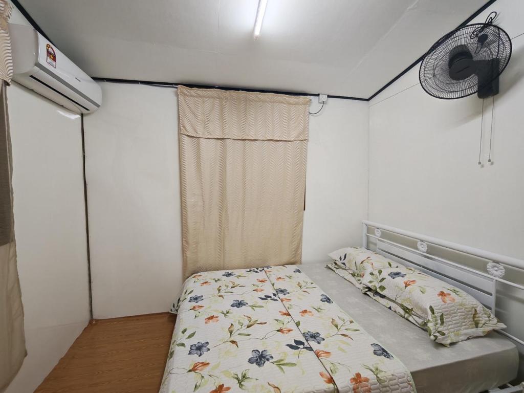 a small bedroom with a bed and a window at Zhan Ruralstay in Kuala Perlis