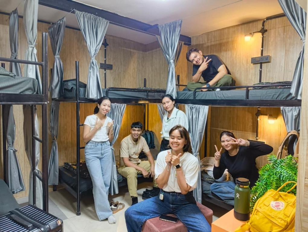 a group of people sitting in a room with bunk beds at Ghumakkads Hostel Near IGI Airport & Aerocity in New Delhi