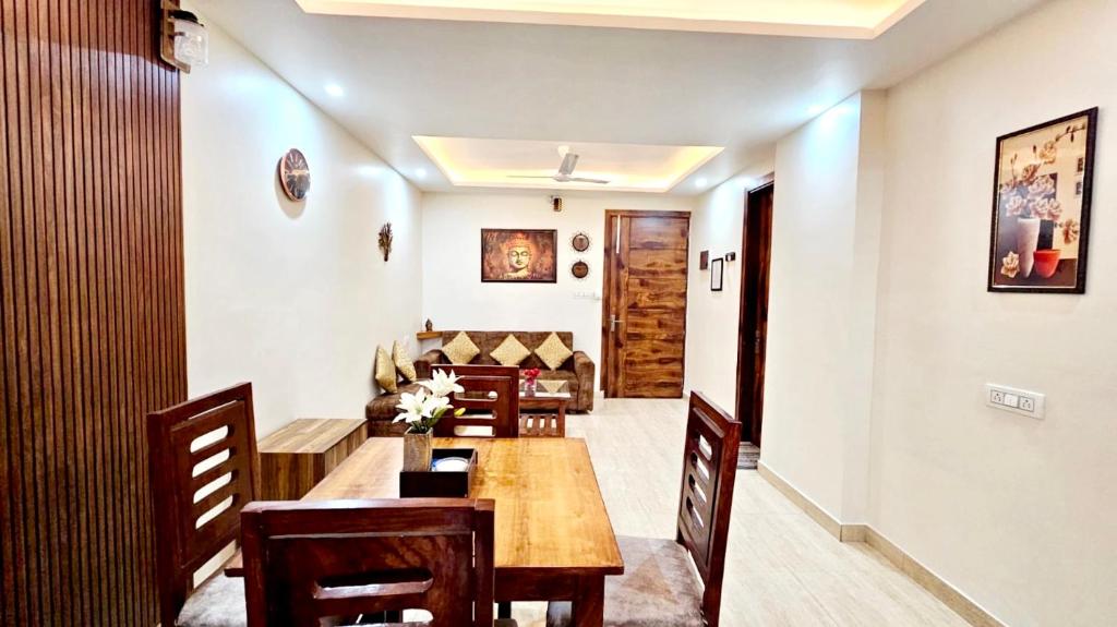 a dining room with a table and a couch at Yogvan Holidays 1BHK Apartments Tapovan Rishikesh in Rishīkesh