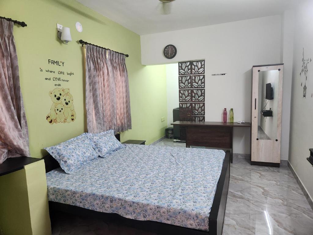 a bedroom with a bed with a blue comforter at VPM Homestay in Coimbatore