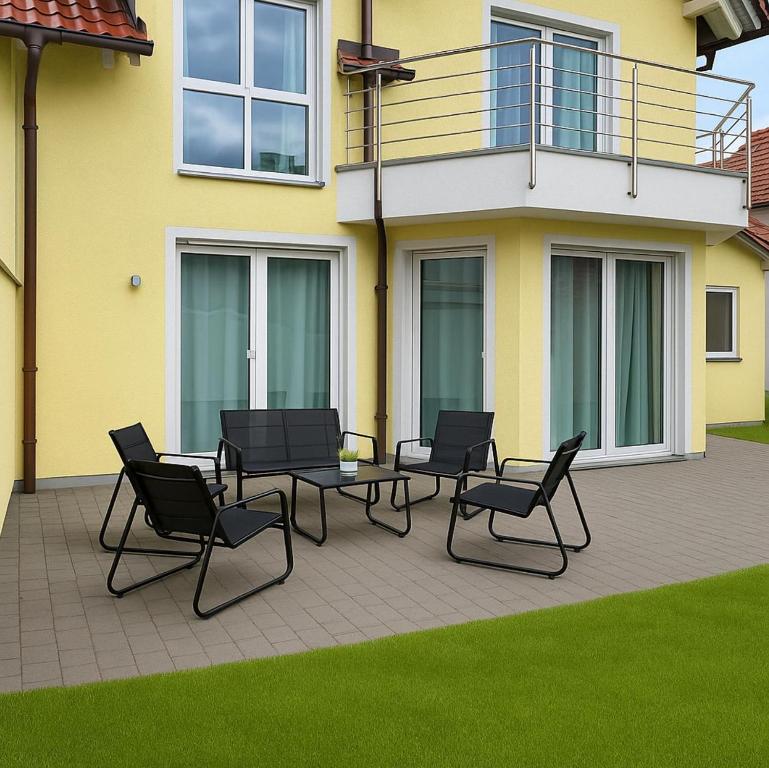 a patio with chairs and a table in front of a house at Luxuriöse Ferienvilla mit Garten, Gaming Zone & Netflix in Langenhagen