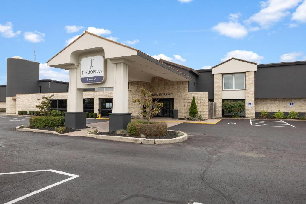 a building with a sign in a parking lot at The Jordan Hotel Ramada by Wyndham in Jordan
