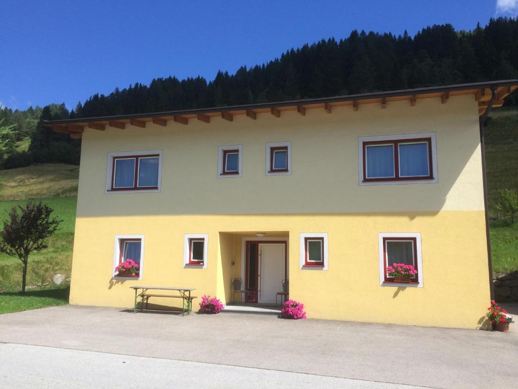 a yellow house with a bench in front of it at Haus Doppler in Sankt Michael im Lungau