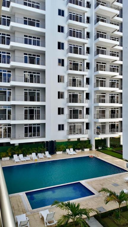 a swimming pool in front of two tall buildings at Kathy's place in Nyali in Mombasa