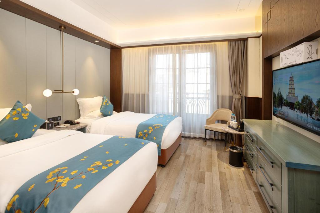 a hotel room with two beds and a flat screen tv at Liban Hotel in Xi'an