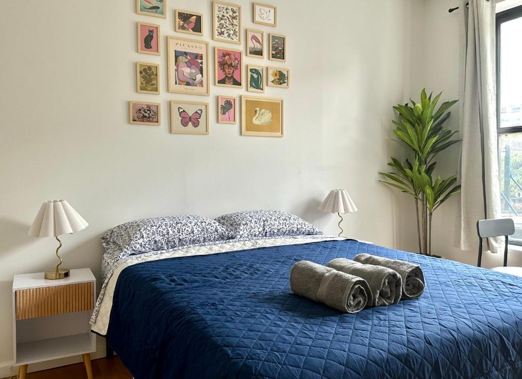 a bedroom with a blue bed with two pillows on it at The Marquee House in New York