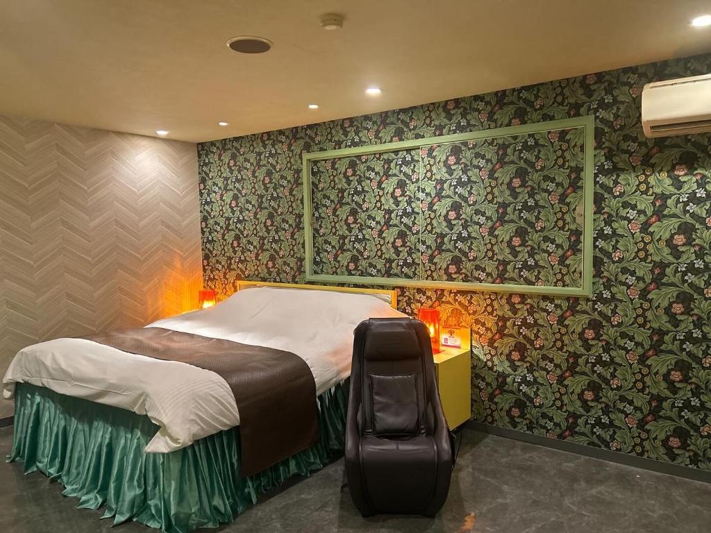 - une chambre avec un grand lit et du papier peint floral dans l'établissement Koriyama Flower Style, à Tenri