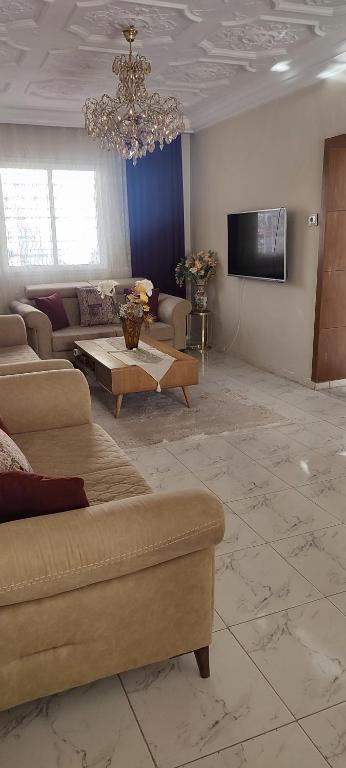 a living room with a couch and a chandelier at Myhouse in Ariana