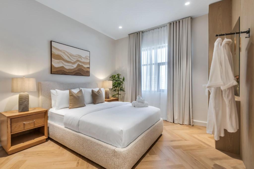 a white bedroom with a bed and a window at The Hideout, Khorfakkan in Khor Fakkan