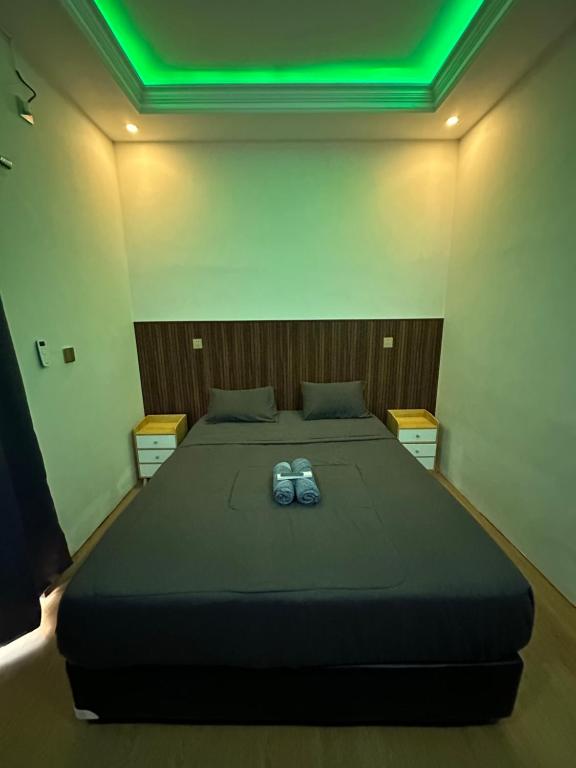 a bedroom with a large bed with green lights on it at alopa villas in Beran-kidul