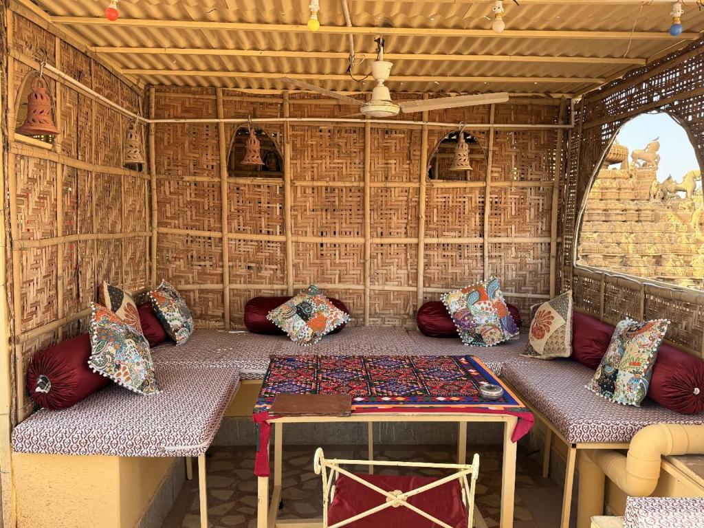 Una habitación con una mesa y almohadas en una tienda de campaña. en Hotel Temple View, en Jaisalmer
