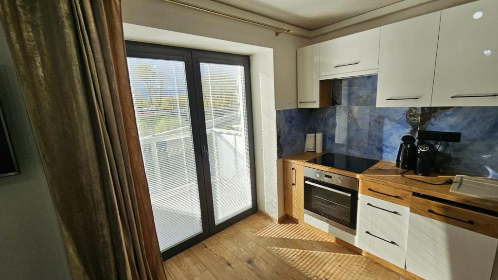 a kitchen with a large window and a kitchen with a stove at Hron River View Apartment in Banská Bystrica