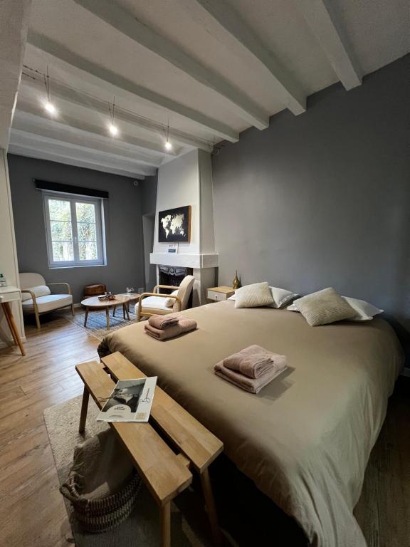 Un dormitorio con una cama grande y una sala de estar. en Bulle D évidence, en Saumur