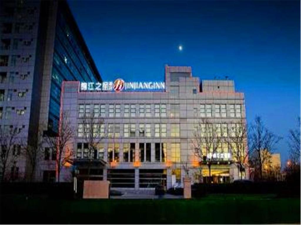 a large building with a sign on top of it at Jinjiang Inn Tianjin Haitai Industrial Parks in Tianjin