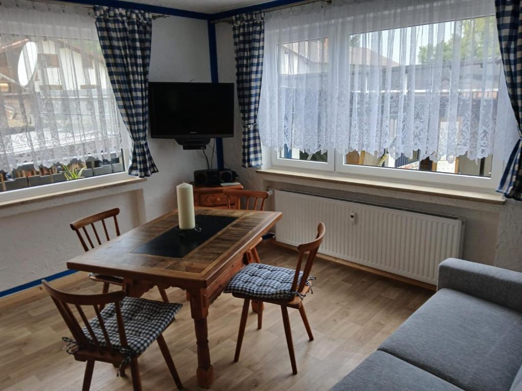 Una sala de estar con una mesa y sillas y un televisor. en beim Anderl, en Oberammergau