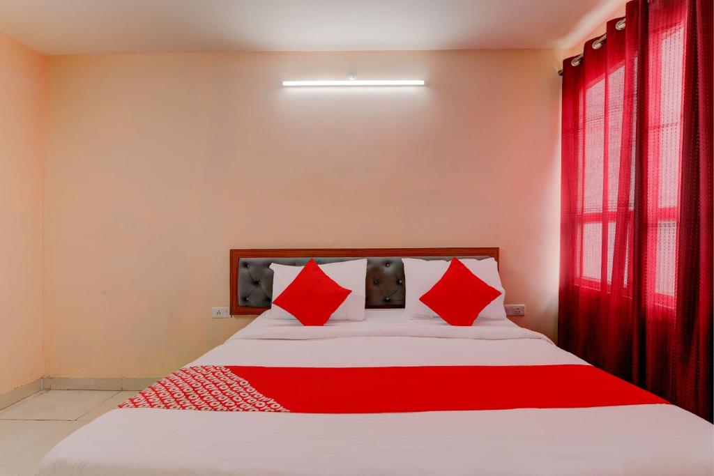 a bedroom with a large bed with red pillows at FabHotel Raas Inn in Lucknow