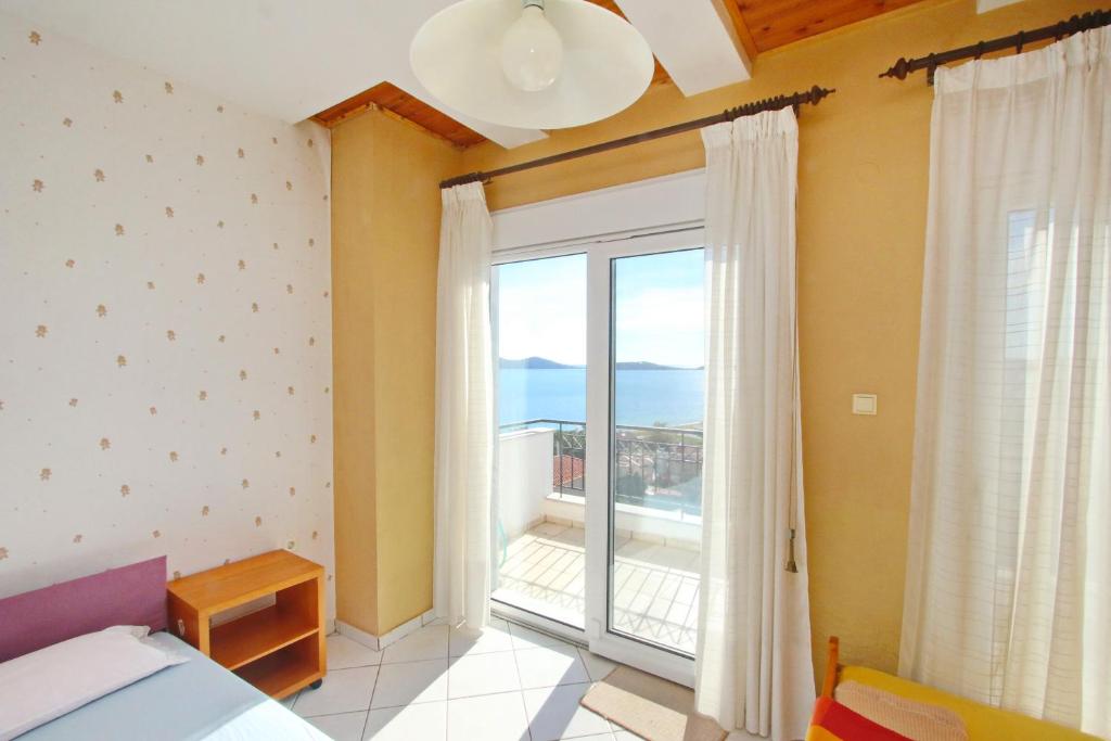 a bedroom with a large window with a view of the ocean at Summer House Nea Peramos in Néa Péramos