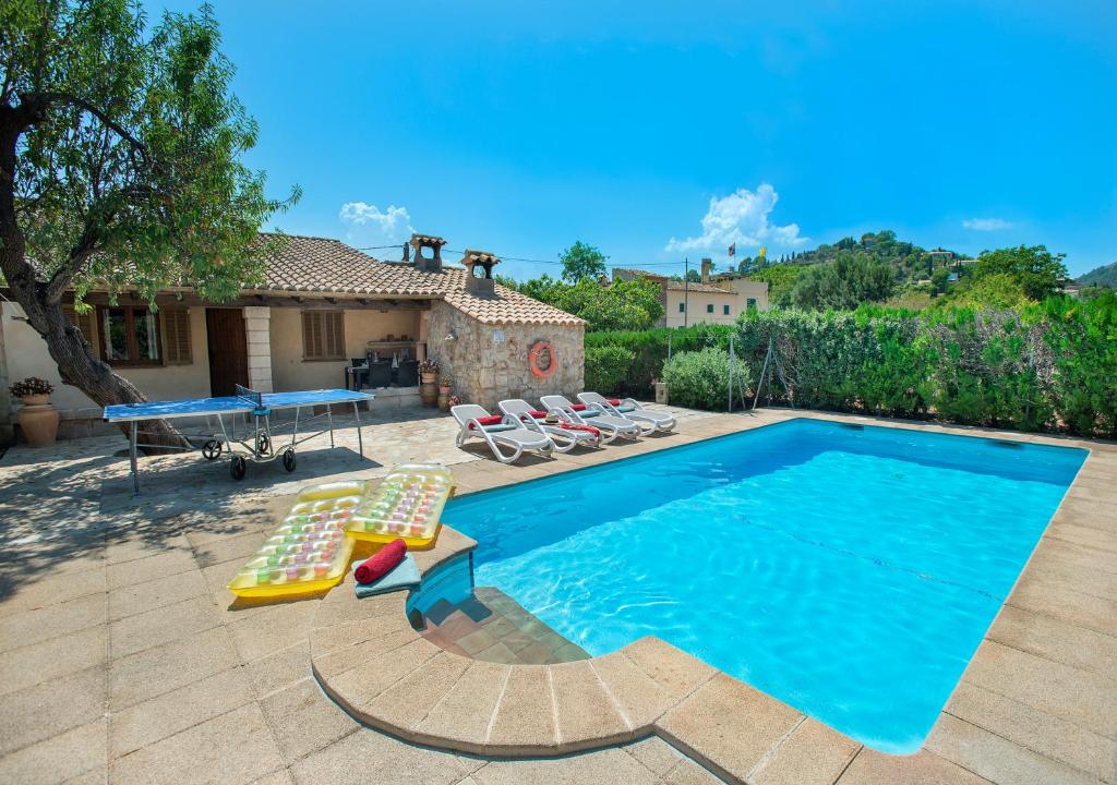 a swimming pool with chairs and a ping pong table at Owl Booking Villa Can Gorreta - 5 Min Walk To The Old Town in Pollença