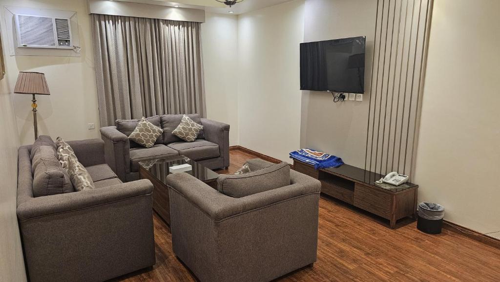 a living room with two chairs and a flat screen tv at Lamar 1 furnished Aparthotel in Riyadh