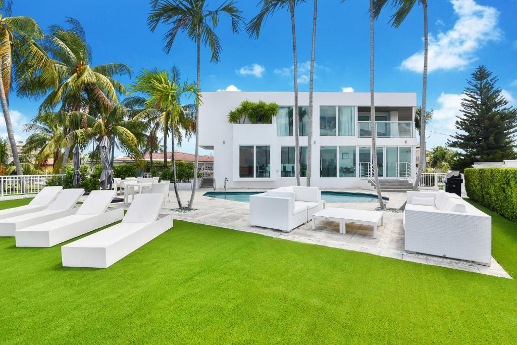 een huis met witte meubels en een groen gazon bij Villa Moonlight Haven in Miami Beach