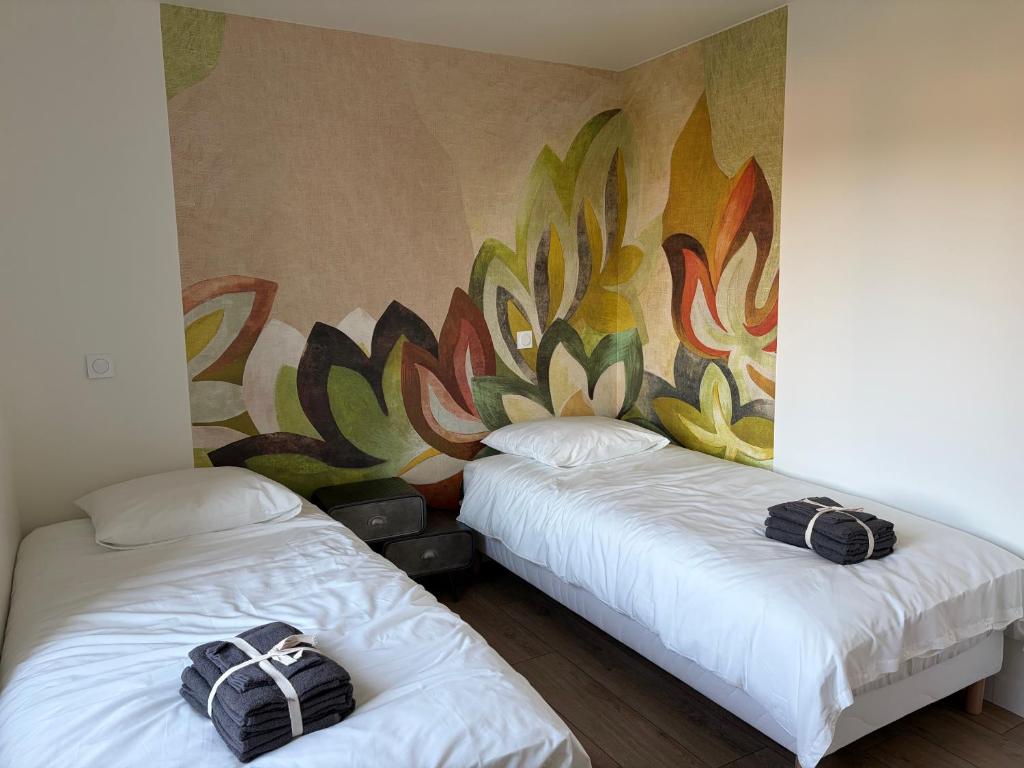 2 Betten in einem Zimmer mit Wandbild in der Unterkunft L'aurore des Volcans in Romagnat