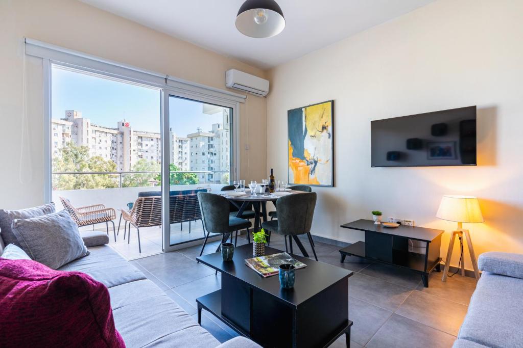 a living room with a couch and a table at Ondo 2-Bedroom Apartment in Larnaca
