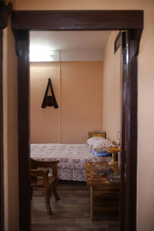 a small bedroom with a bed and a table at Reyan Homestay in Kohīma