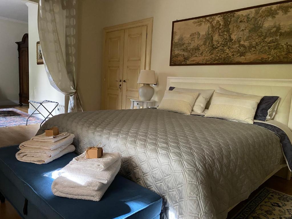 a bedroom with a large bed with towels on it at Stanze Degli Aceri in Murazzano