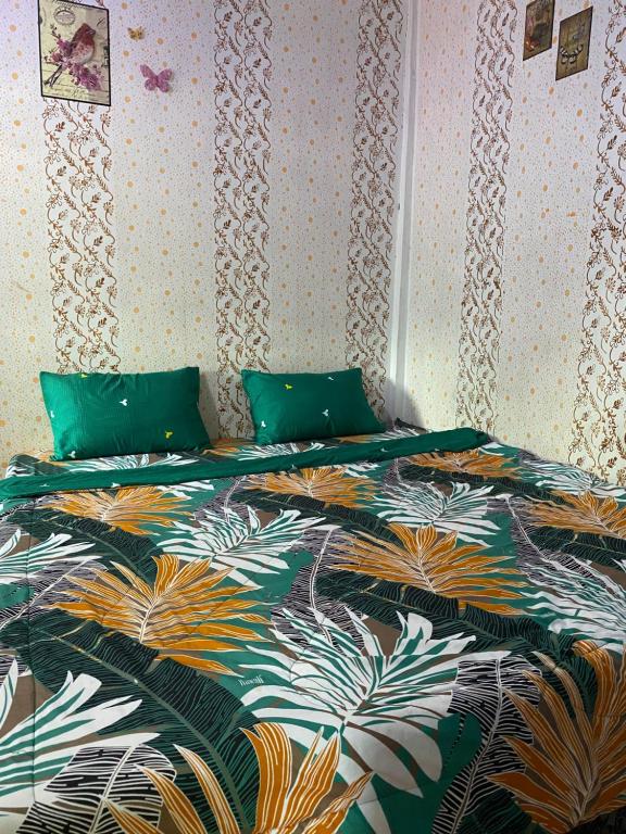 Un dormitorio con una cama con un edredón colorido. en Explore Jungle Trek Guesthouse & Transport, en Bukit Lawang
