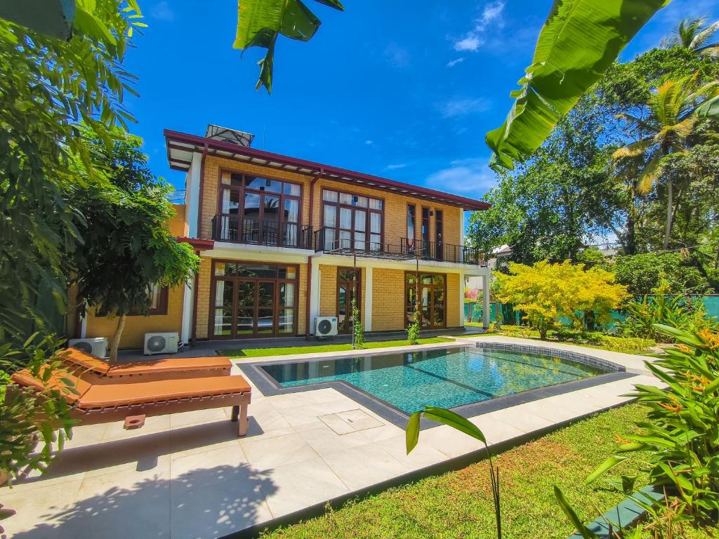 Una vista exterior de una casa con piscina. en Syndeo Garden, en Hikkaduwa