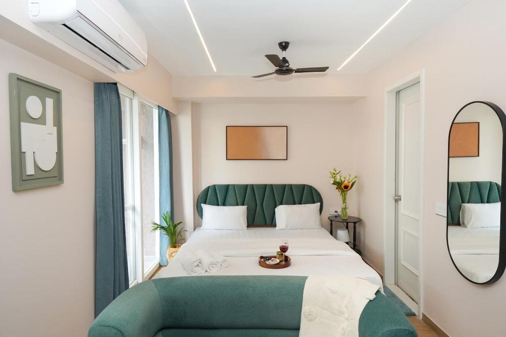 a bedroom with a large bed with a green couch at UHomes Pune airport in Pune