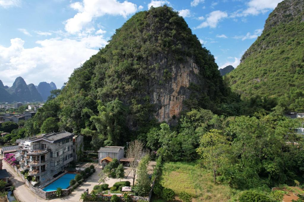 a view of a mountain with a resort and a river at Qingshan Yuandai Boutique Homestay Yangshuo in Yangshuo